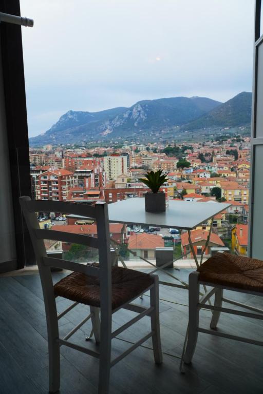 Balcone con tavolo e sedie, città e colline sullo sfondo