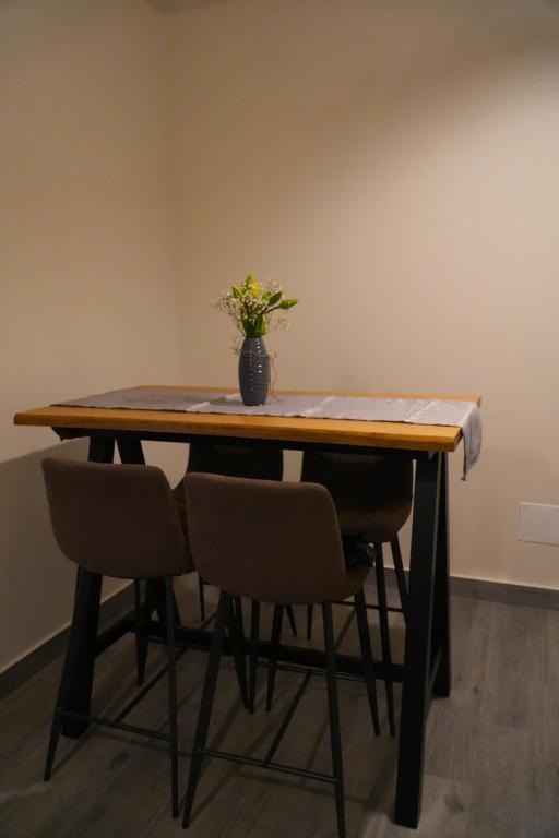 Tavolo in legno con quattro sedie e un vaso di fiori